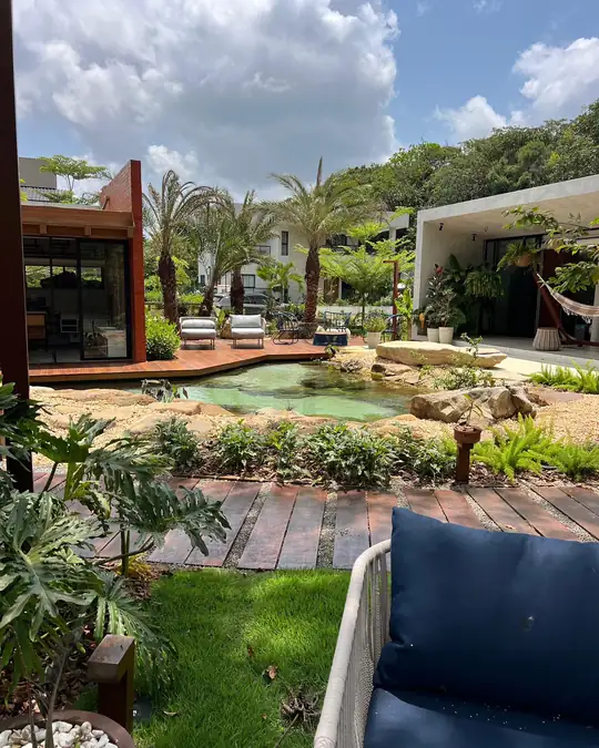 Casa, deck de madeira e lago vistos do gramado de uma residência em Aldeia